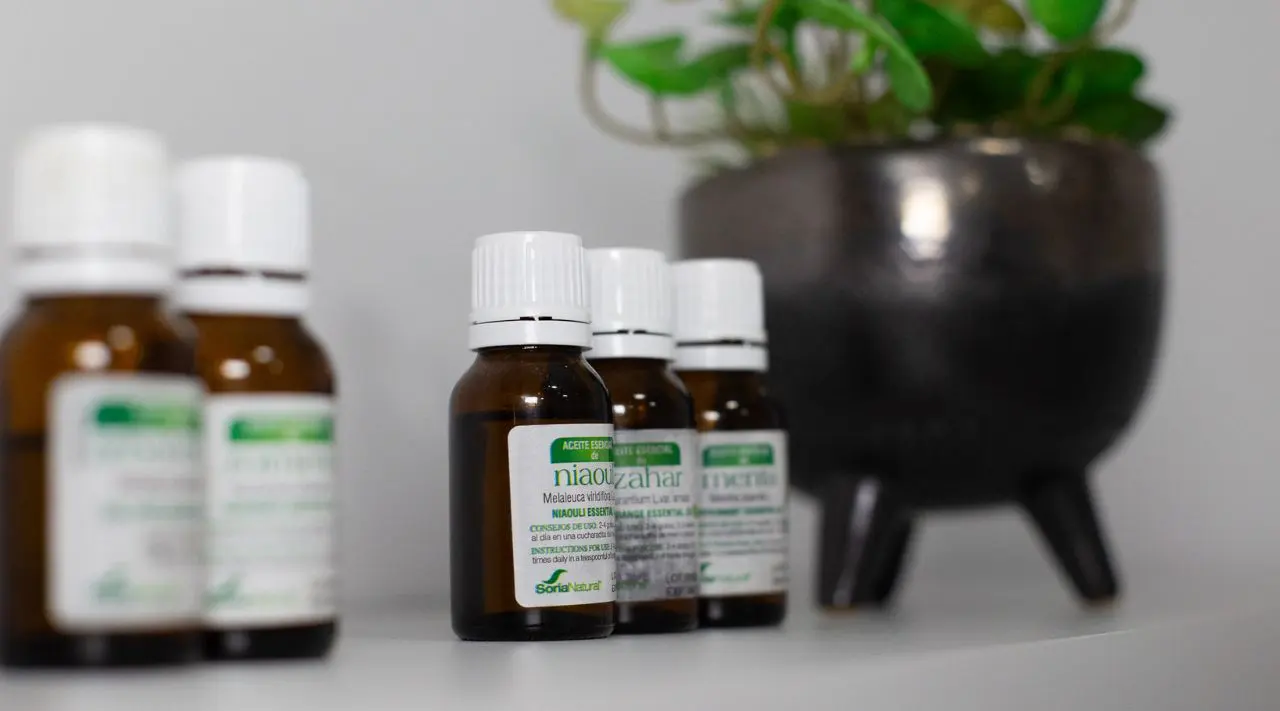 Bottles of essential oils next to a plant
