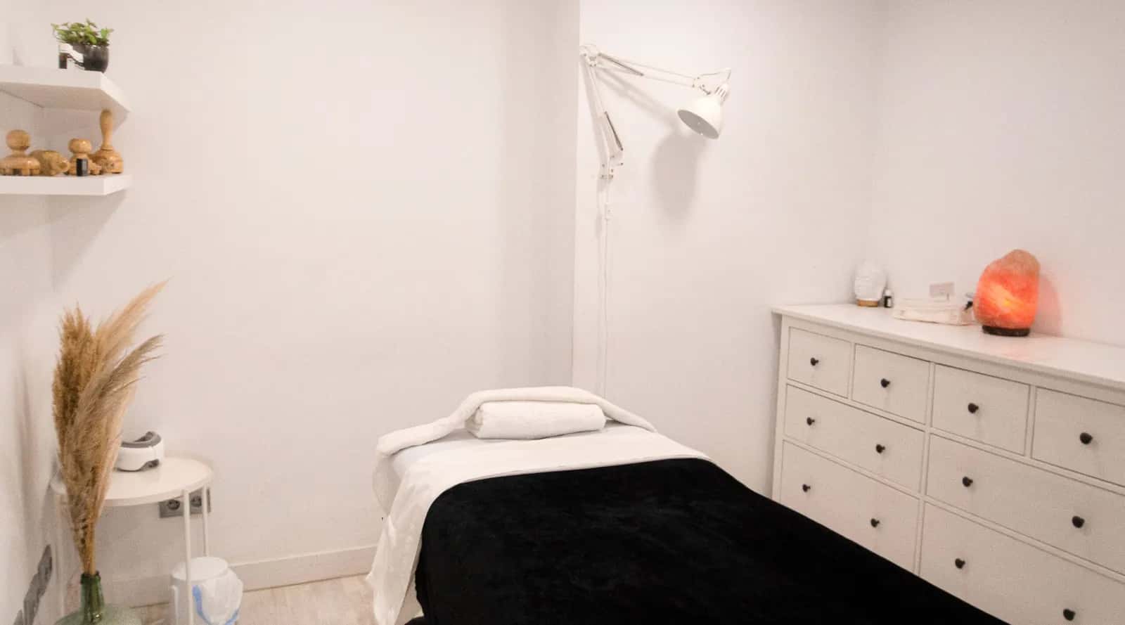 Cabina de Adara Essence con la camilla preparada y una lámpara de sal