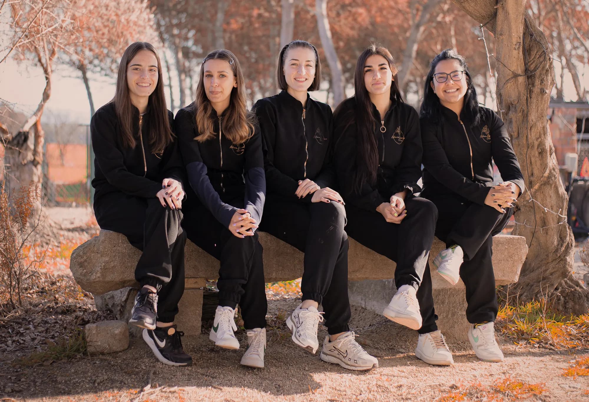 L'equip d'Adara Essence assegut en un banc de pedra al costat de la masia