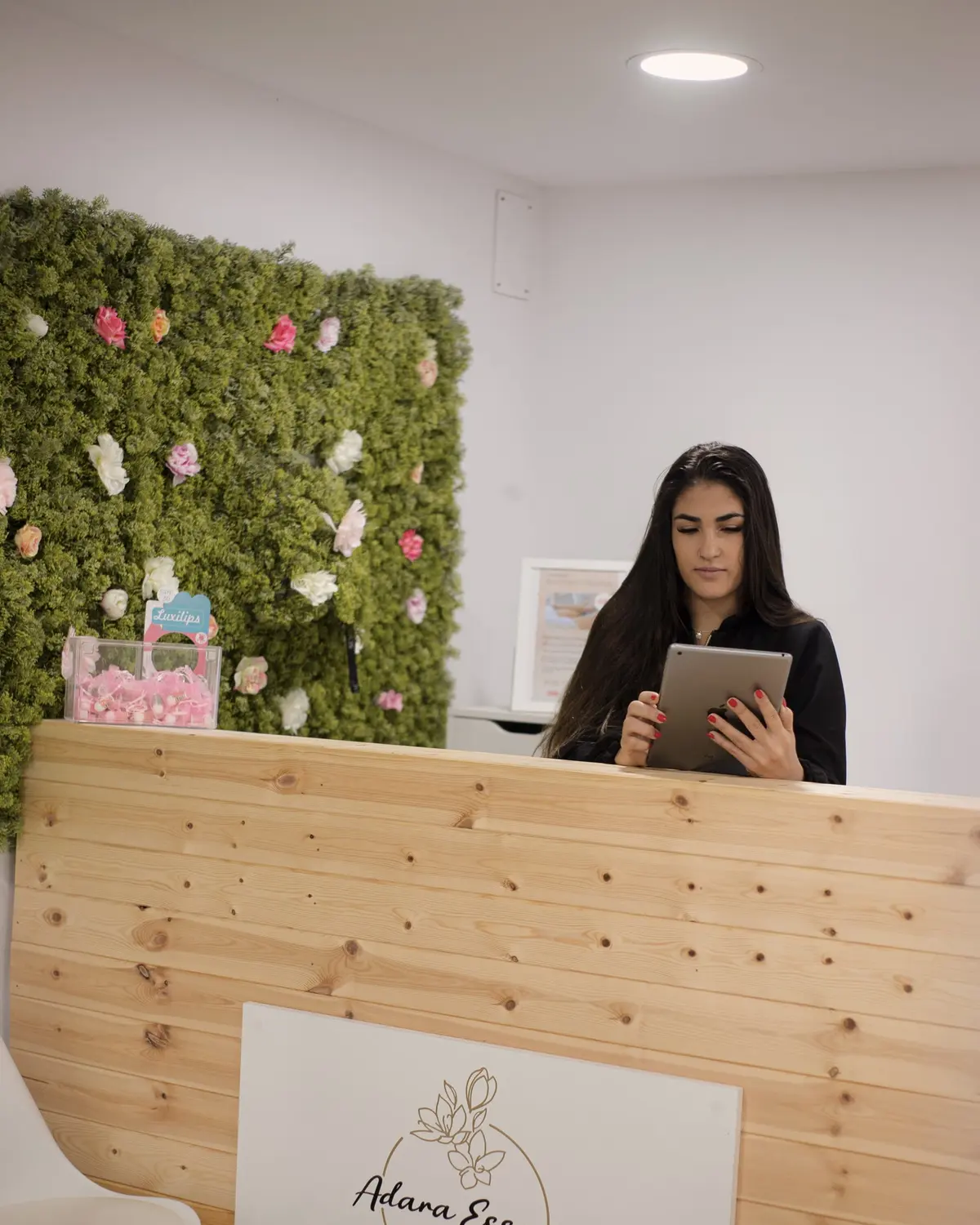 Recepción de Adara Essence, con una pared de plantas y flores